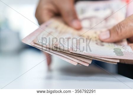 Weak Baht, Thai Baht Banknotes, Businessman's Hands Counting Money. One Thousand Baht. (thb) Is Offi