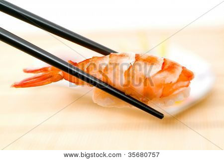 Sushi con le bacchette, con un fondo schiena