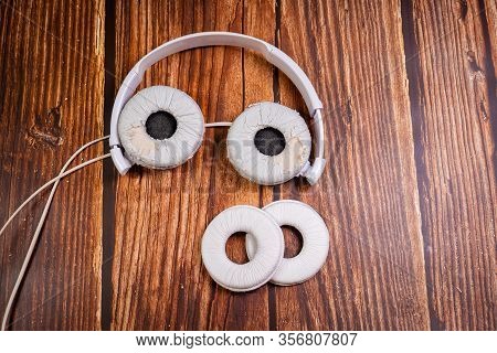 Need A Replacement Embouchures On Old White Earbud. Repair Accessories.wooden Background