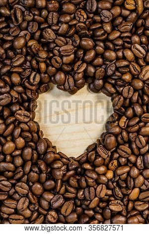 Roasted Brown Coffee Beans With Empty Heart Form Shape.