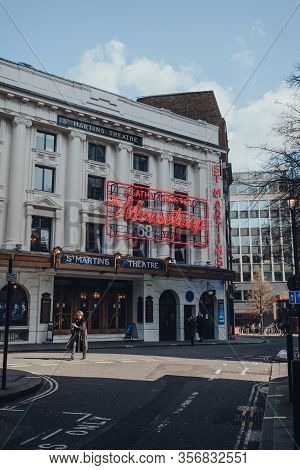 London, Uk - March 06, 2020: Woman Walking Past Mousetrap Neon Sign On The Facade Of St Martins Thea