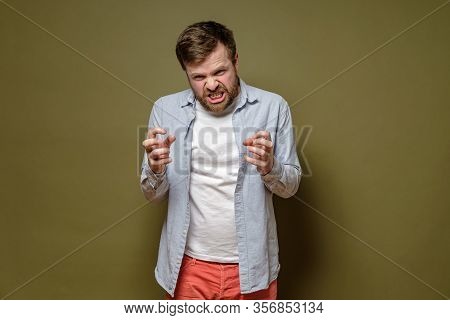 Frenzied, Bearded Man, Clenches Fists In Fury And Grins Teeth Angrily. Isolated, On A Green Backgrou