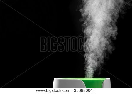 Ultrasonic Humidifier Releases Water Vapor From The Hole. On Black Background. The Process Of Operat