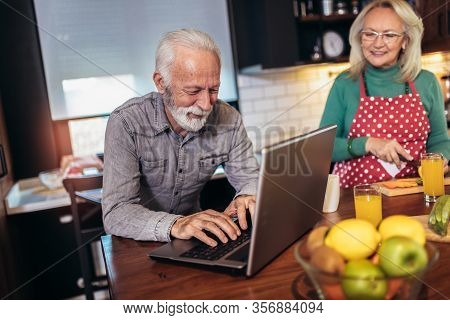 Happy Retired Couple Browsing The Internet Together On A Laptop Computer.quarantine. Health Concept.