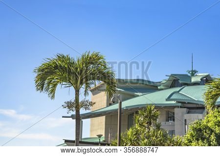Building Of Okinawa Convention Center Decorated With Palm Trees Near The Tropical Beach Of Ginowan C