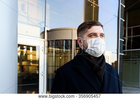 Caucasian Young Man Near His Office Wearing Surgical Face Mask To Protect From Coronavirus Covid-19