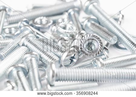 Metal Bolts And Nuts  In A Row Background. Chromed Screw Bolts And Nuts Isolated. Steel Bolts And Nu
