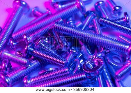 Metal Bolts And Nuts  In A Row Background. Chromed Screw Bolts And Nuts In Blue And Pink Tones. Stee