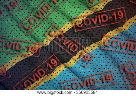 Tanzania Flag And Many Red Covid-19 Stamps. Coronavirus Or 2019-ncov Virus Concept