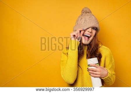 A Girl With Clean Skin In A Yellow Sweater Stands On A Yellow Background Laughing Joyfully Holds A T