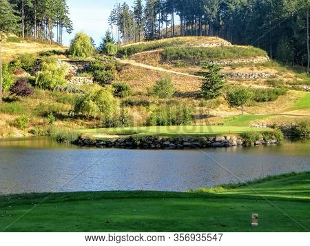 A View From The Tee Box Of A Beautiful Island Green Par 3 Surrounded By Water At A Golf Course Outsi