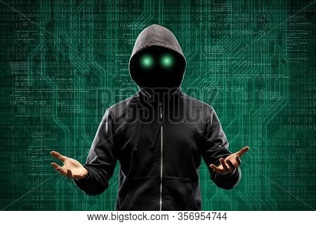 Computer Hacker In Mask And Hoodie Over Abstract Binary Background. Obscured Dark Face. Data Thief, 