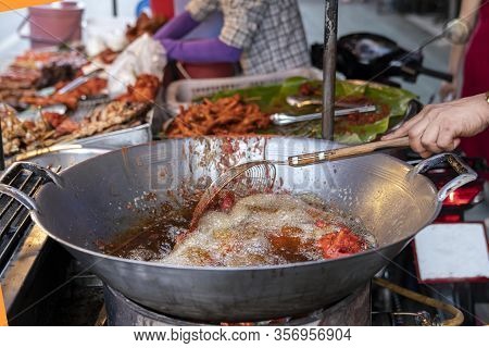 Street Food In Thailand. Deep-fried Chicken Using A Large Frying Pan With Boiling Oil. Food From Car