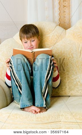 ragazzo legge libro su divano