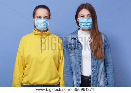 Close Up Portrait Of Two Women Wearing Casual Outfit And Health Masks, Trying To Prevent From Flu, C