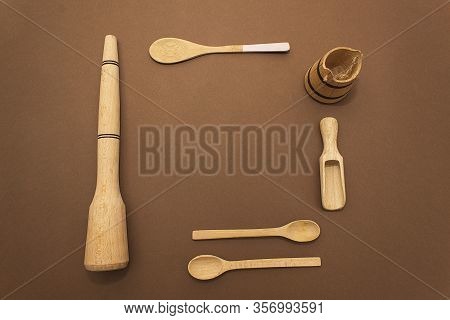 Wooden Kitchen Spoons On A Brown Paper Background. Concept Of Eco Tools, No Plastic. Ziro Waste