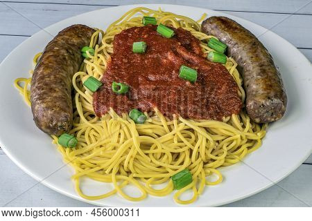 Spaghetti And Sweet Italian Sausage Served With Sauce And Green Onions,