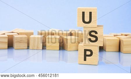 On A Bright Blue Background, Wooden Blocks And Cubes With The Text Usp. Cubes Is Reflected From The 