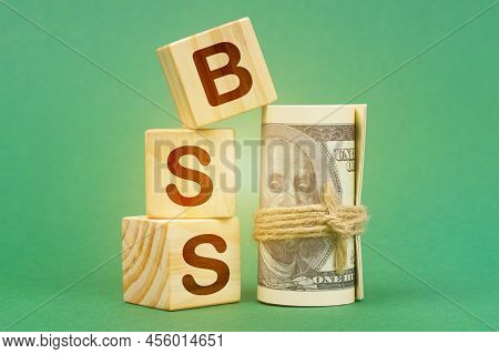 Business Concept. On A Green Surface, Dollars And Cubes With The Inscription - Bss