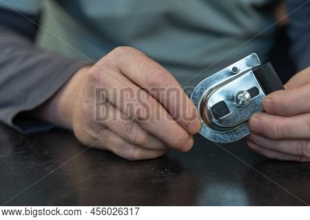An Adult Male Holding A Top Roller Mount For A Sliding Closet System. Adjustable Mounting Plate For 