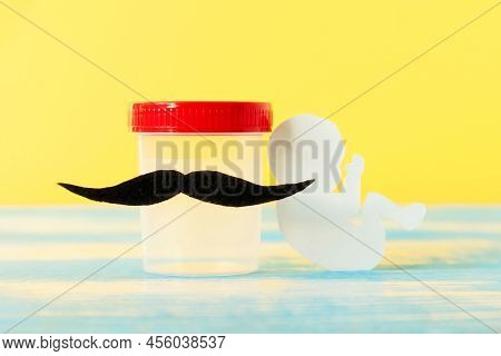 Test-tube With Sample Of Sperm With Felt Moustache And Paper Embryo. Yellow Background. Concept Of A