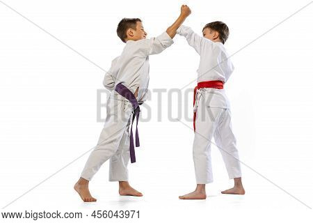 Dynamic Portrait Of Two Little Boys, Taekwondo Or Karate Athletes Wearing Doboks Training Together I