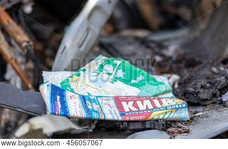 The Car Burned Down Completely. A Paper Map Of The City Of Kyiv In The Interior Of A Destroyed Car.
