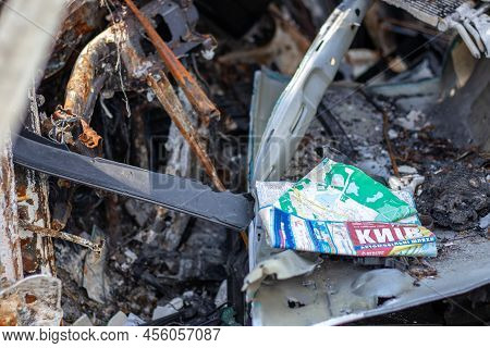 The Car Burned Down Completely. A Paper Map Of The City Of Kyiv In The Interior Of A Destroyed Car.