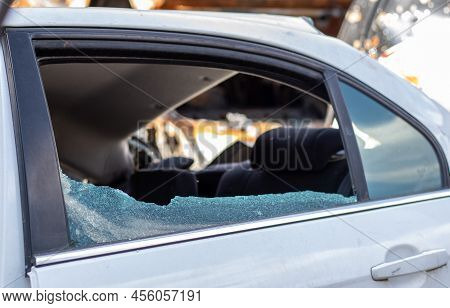 Criminal Incident. Breaking Into A Car Parked On The Street. Broken Side Glass And The Passenger Com