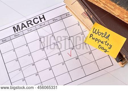 World Puppetry Day Concept. 21 March Ticked Off In The Calendar. Stack Of Old Books.