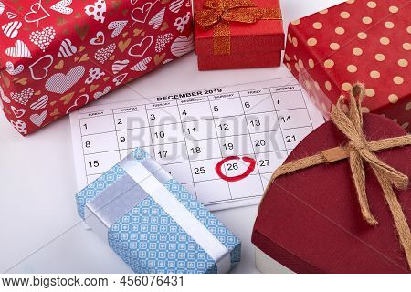 Boxing Day Concept. Red Gift Boxes And December Calendar With Mark On 26 Day. Top View White Backgro