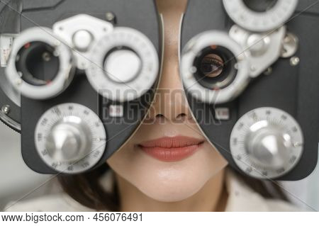 Young Female Customer Being Examined Visual Test Using Bifocal Optometry Eyesight Measurement Device