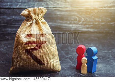 Family Figurines And Indian Rupee Money Bag. Social Assistance And Support. High Debt. Social Resear