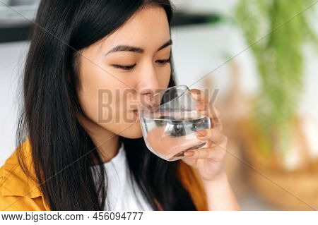 Leading A Healthy Lifestyle. Close-up Of A Happy Asian Girl, Drinks A Glass Of Clean Water With Plea