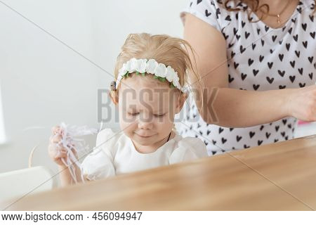 Mother Helps To Put On Cochlear Implant For Her Deaf Little Daughter. Hearing Aid And Deafness And D