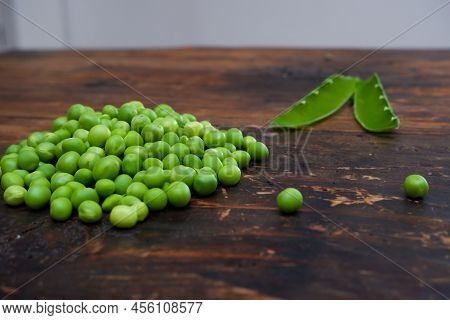 Fresh Peeled Green Pease On A Brown Wooden Table With Copy Space. Fresh Pods Of Green Peas Horizonta