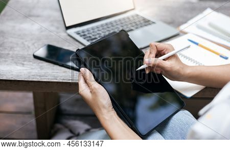 Young Asian Woman In Casual Clothing Working At Outdoor Cafe, Using Tablet Computer Working Or Study