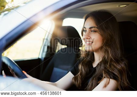 Beautiful Young Modern Girl Driving A Car On Sunny Summer Day. Female Driver Alone In The Car, Close
