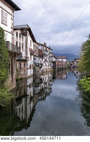 Old Houses On The Edge Of A Channel On The Bidasoa River With The Buildings Reflecting On The Water,