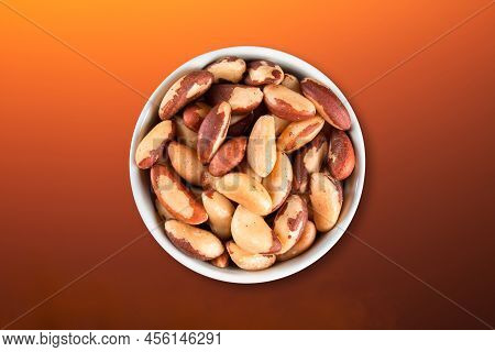 Brazil Nuts In Bowl Top View With Colored Gradient Background.