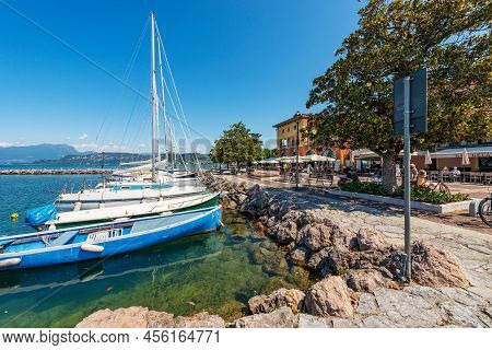 Cisano Di Bardolino, Italy - May 26, 2021: Small Port Of Cisano Village With Boats Moored. Tourist R