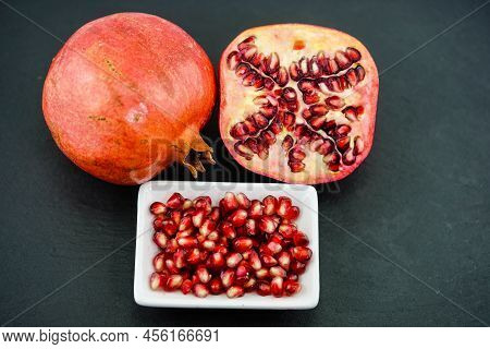 Sliced Red Pomegranate On A Black Slate