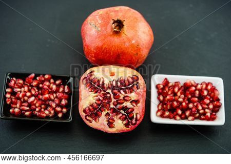 Sliced Red Pomegranate On A Black Slate