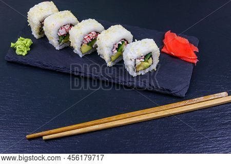 Uramaki Sushi Rolls With Surimi On A Black Slate