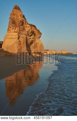 Red Colored Limestone Rock Reflecting In The Low Tide Water. Praia Do Amado In Algarve Region, Portu