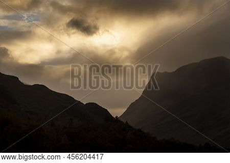 Stunning Autumn Sunrise Landscape Image Of Buttermere In Lake District With Dramatic Stormy Sky