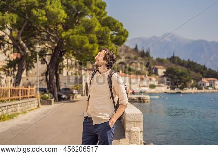 Man Tourist Enjoying Colorful Street In Old Town Of Perast On A Sunny Day, Montenegro. Travel To Mon
