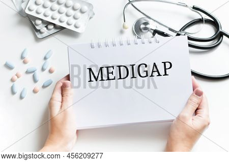 Doctor Holding A Paper Plate With Text Medigap Medical Concept