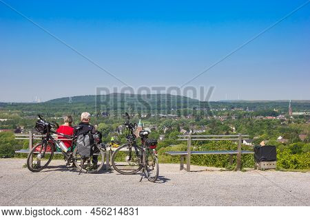 Bottrop, Germany - May 09, 2022: Senior Couple Resting On A Bench On Top Of The Hill Overlooking The