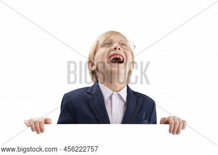 Cheerful Boy Posing With Empty White Paper Board And Laughs. Cute Blond Boy Peeking Out From Behind 